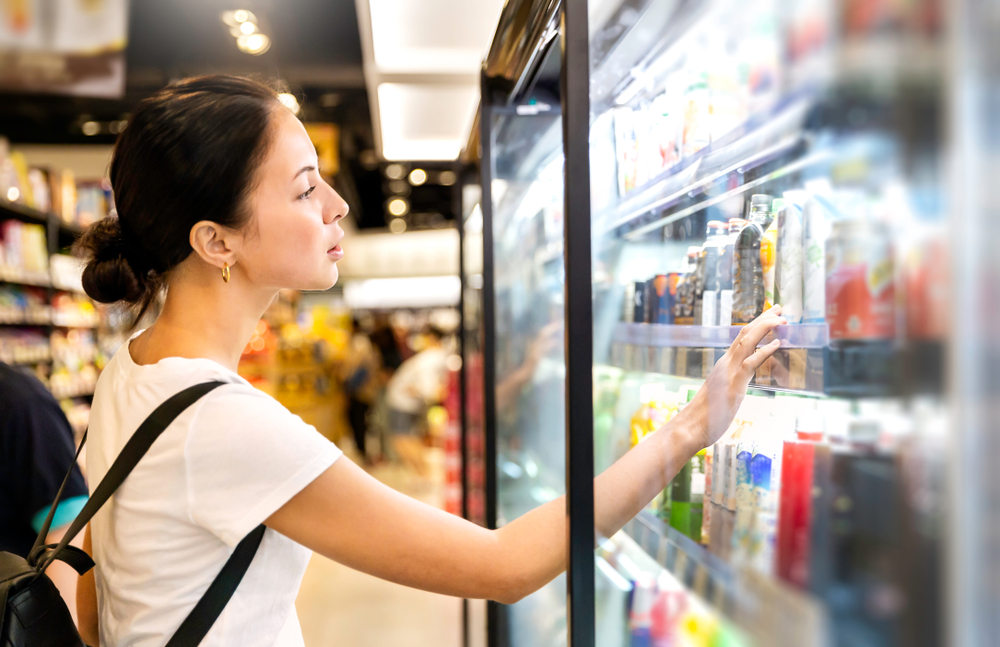 Lady looking at beverages in the supermarket chiller